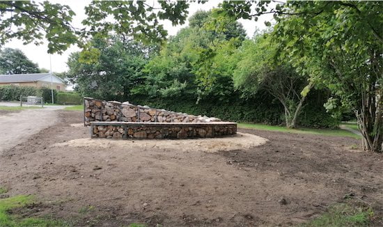 Stenmur i park omgivet af grønne træer