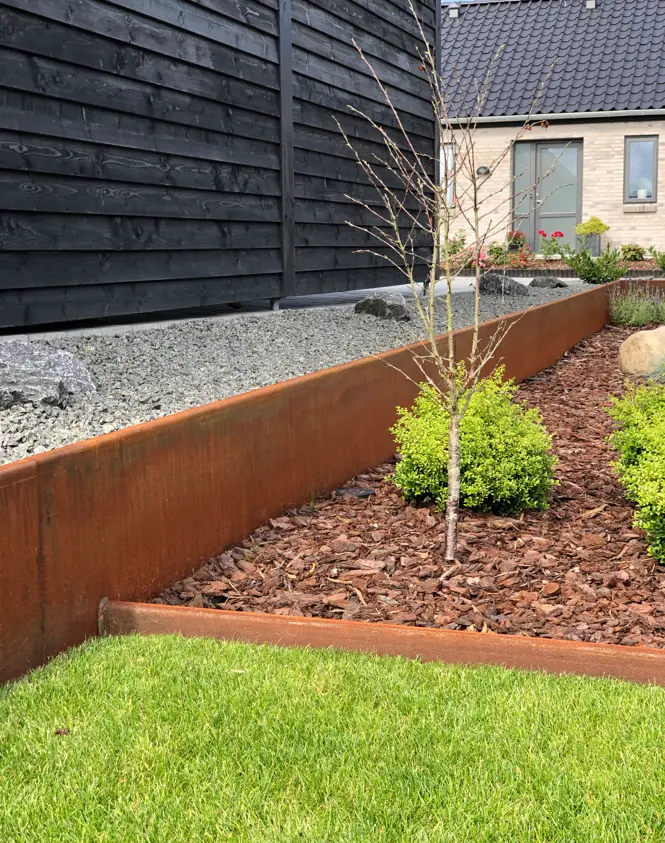 Højbed med cortenstål og nyplantet træ i have