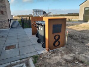 Moderne postkasse og affaldsbeholdere foran hus nummer otte