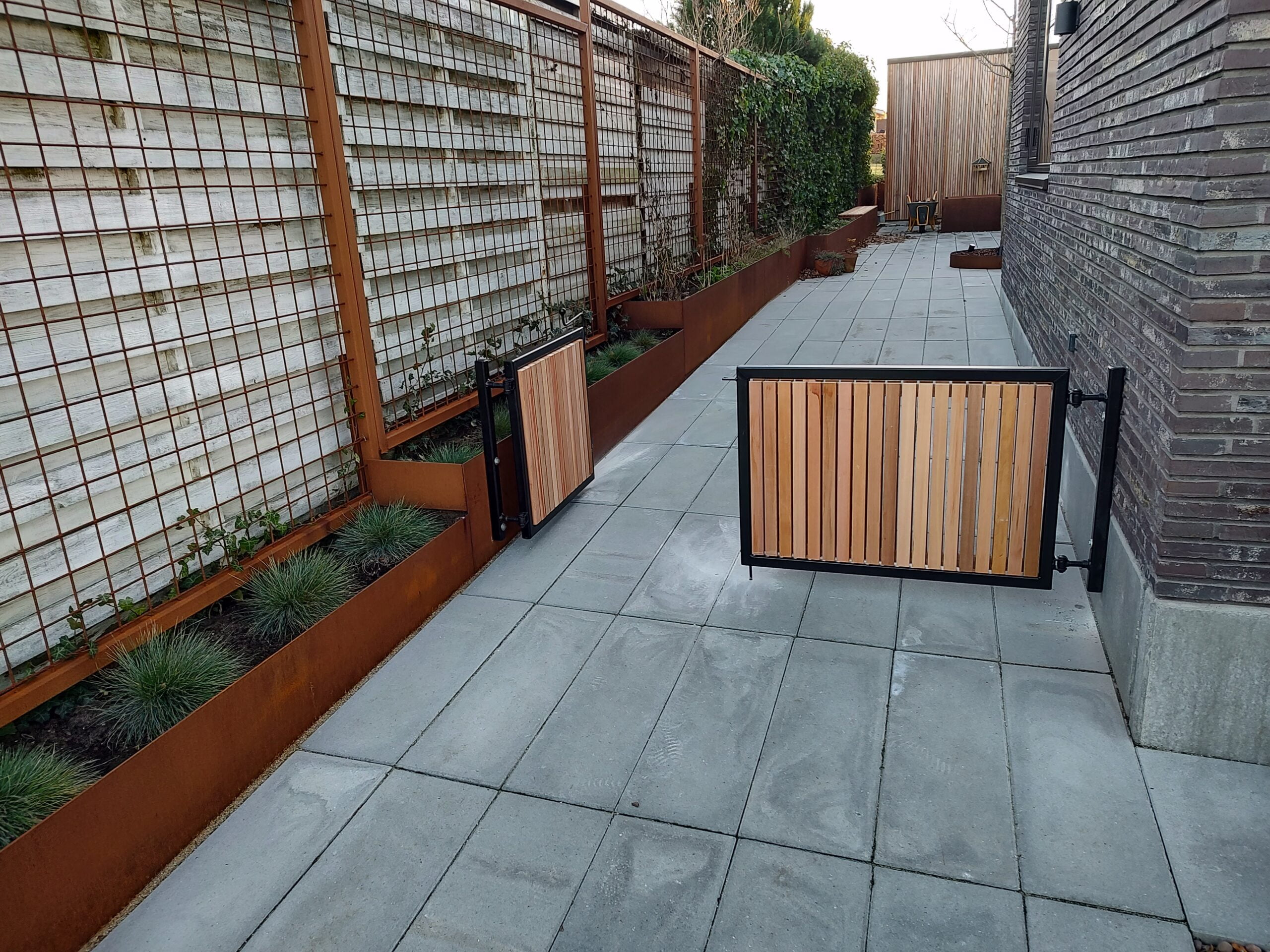 Moderne gårdhave med træport og plantekasser