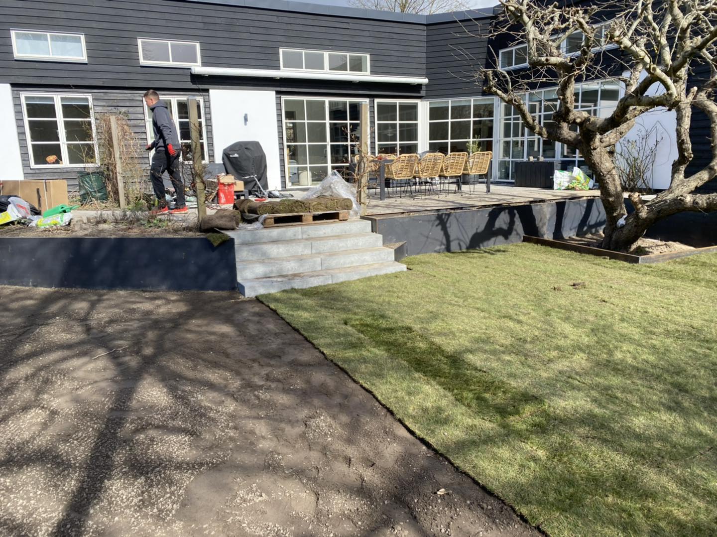 Nybygget terrasse med havearbejde foran moderne hus