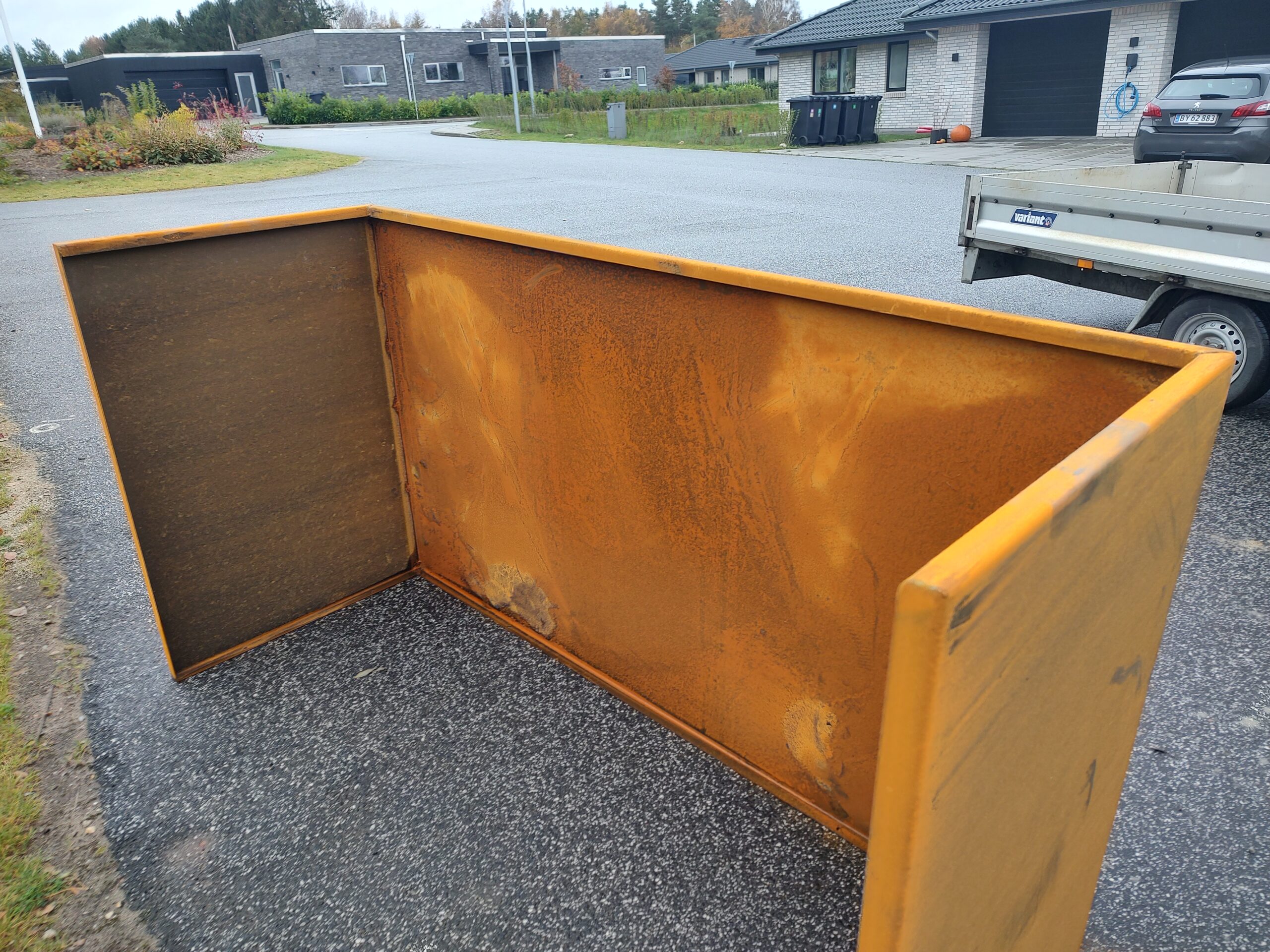 Stor rusten metalcontainer på villavej